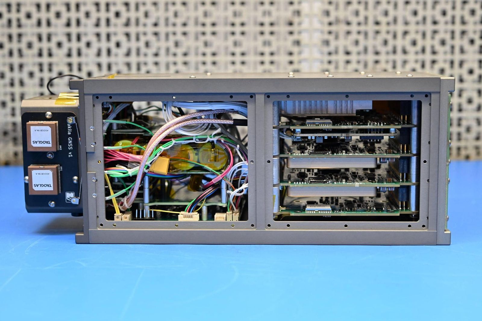 Kilakila satellite chassis during assembly, showing the stacked payload boards and dual GNSS antennas